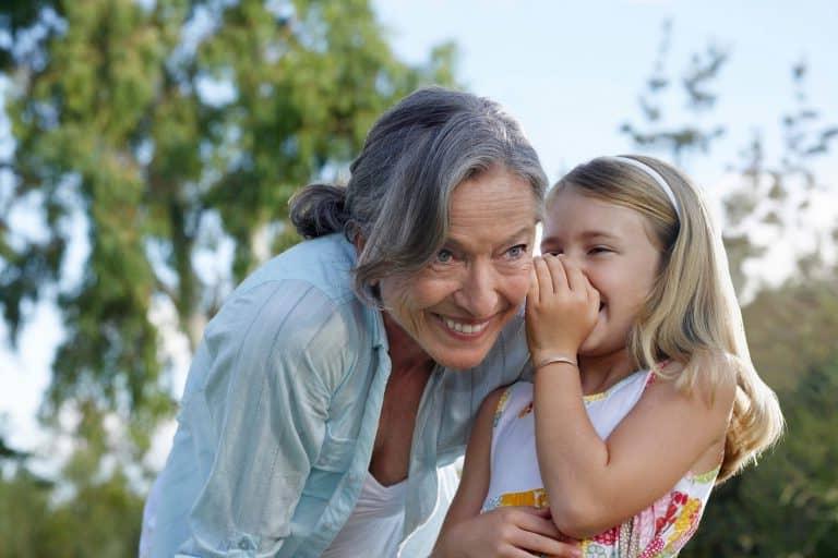 girl whispering to older woman